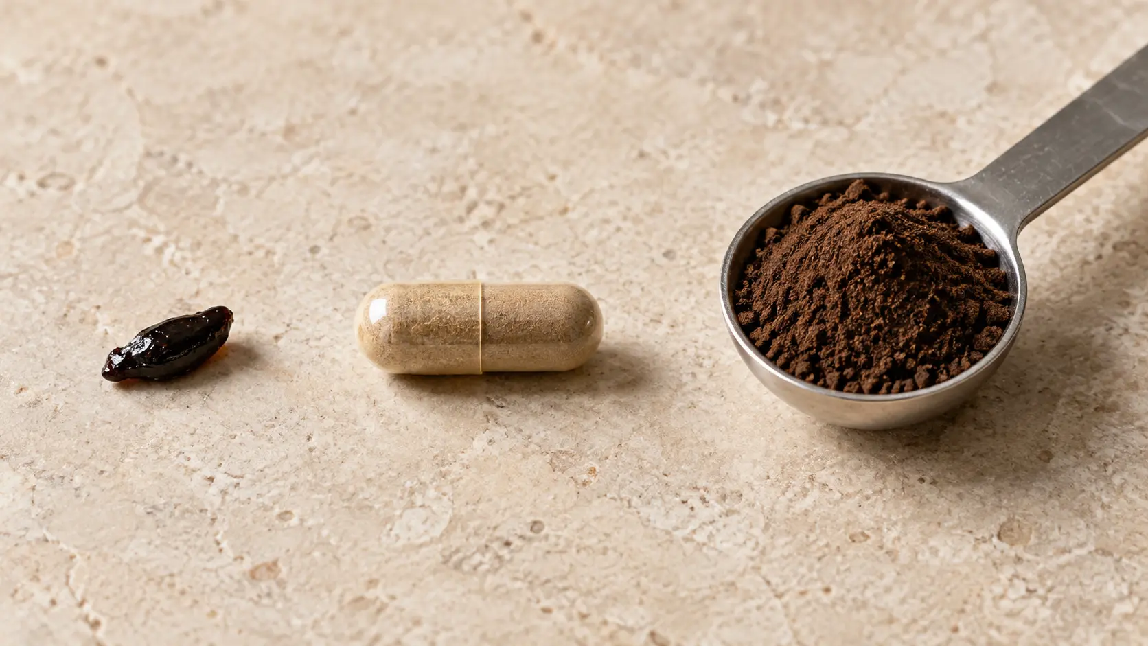 Grain de riz de résine de shilajit à côté d'une gélule et d'une cuillère doseuse de poudre